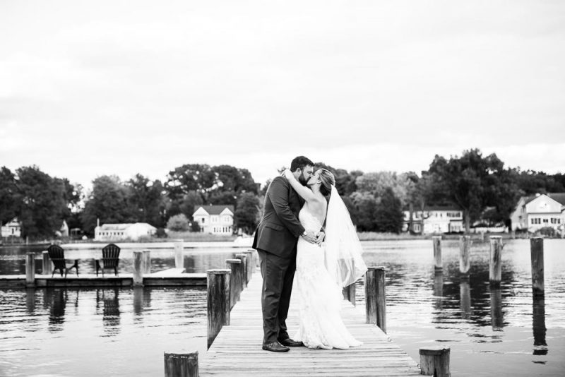 bride and groom kissing on the dock